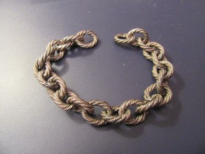 rope bracelet on a black surface with a silver clasp