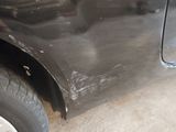 a close up of a car ' s front fender with a hole in it