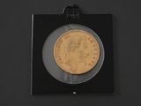 a close up of a gold coin in a black frame