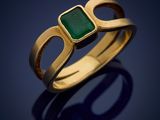 a gold ring with a green stone in the middle