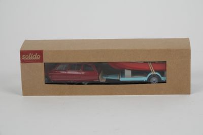 deux petites voitures rouges et bleues dans une boîte en carton posée sur une surface blanche