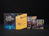 three dvds and a box of games on a black surface