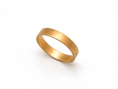 gros plan d'une bague en or sur fond blanc