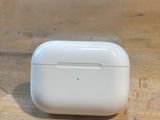 des AirPods d'Apple posés sur une table à côté d'une boîte transparente