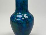 a blue vase that is sitting on a table