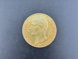 a close up of a gold coin on a black surface