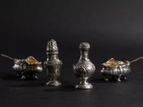 three silver objects on a black surface with a black background