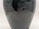 a black vase with a dragon on it on a white background