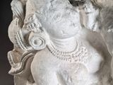 statue of a seated woman with a bird on her shoulder