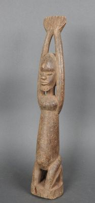 une petite statue représentant un homme tenant un oiseau dans ses mains
