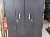 a metal cabinet in a garage with a fire extinguisor