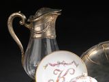 un pichet en verre et un plateau en argent avec un bol et une tasse