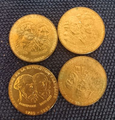 three different types of gold coins sitting on top of a blue cloth