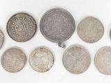 a group of six different coins sitting on top of a white surface