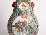un vase avec un tableau posé sur une table