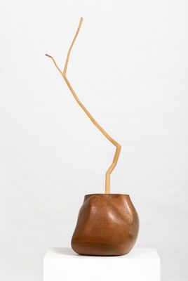 a small wooden vase sitting on top of a white pedestal