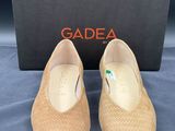 une paire de chaussures beiges avec une boîte sur un fond bleu