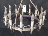 a chandelier made out of sticks and white candles