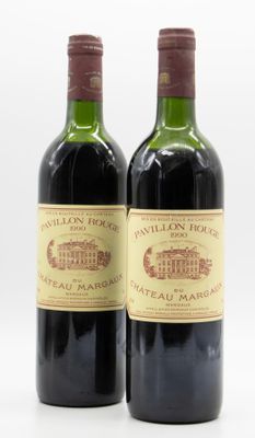 deux bouteilles de vin rouge posées l'une à côté de l'autre sur une surface blanche