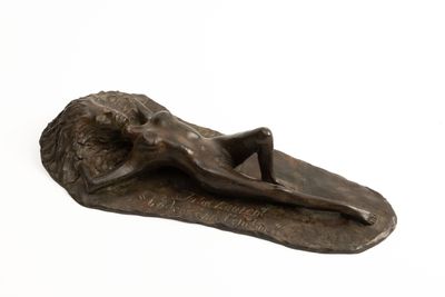 bronze sculpture of a woman laying on a leaf