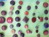 many different types of buttons on a green surface