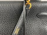 a black leather handbag with gold hardware