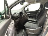 the interior of a car with the door open and the driver ' s seat down