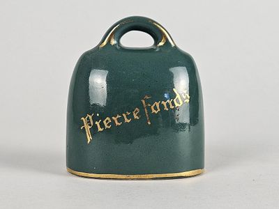une cloche verte avec des lettres dorées sur fond blanc