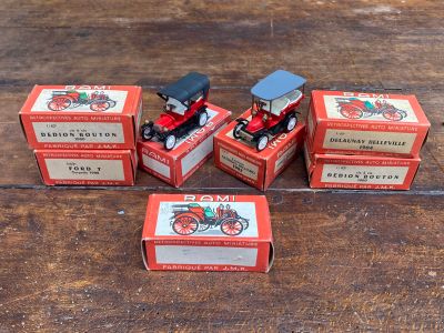 quatre petites boîtes rouges contenant des jouets assortis, posées sur une table en bois