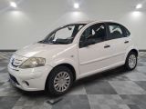 a picture of a small white car parked on a checkered floor