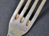 a silver fork with a black dot on it