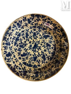 assiette bleue et blanche ornée d'un motif floral sur fond blanc