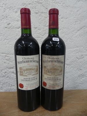 deux bouteilles de vin rouge posées sur une table en bois