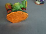 toy figurines are sitting on a table with a coin in the foreground
