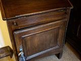 une petite armoire en bois surmontée d'un tableau