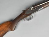 a close up of a rifle with a wooden handle on a table