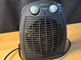 un petit radiateur soufflant posé sur une table en bois