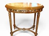 a round table with a wooden top and carved legs