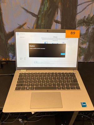 un ordinateur portable ouvert posé sur un bureau près d'un mur