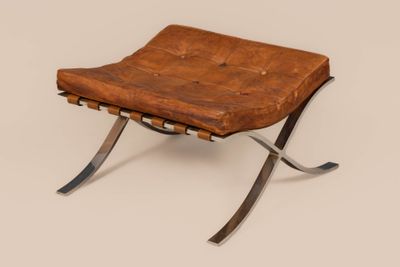 a brown leather chair sitting on top of a metal frame