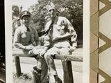 a black and white photo of two men sitting on a bench