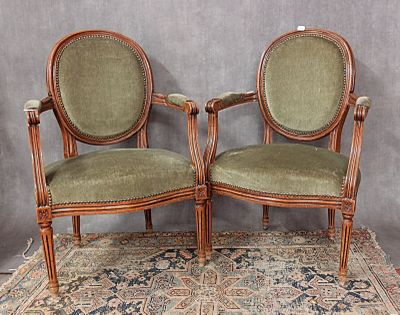 une paire de fauteuils rembourrés verts posés sur un tapis à fond gris