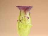 purple and green glass vase sitting on top of a white surface