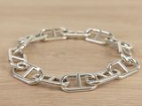 silver plated link bracelet with square links on a wooden surface