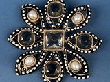 a black and white broochle with pearls and pearls