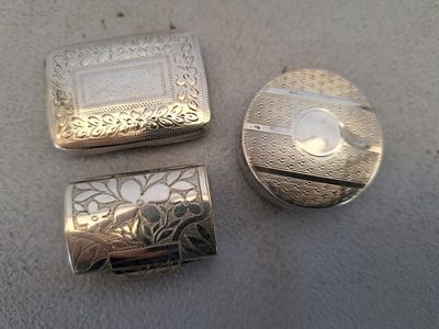 deux boîtes en argent posées l'une à côté de l'autre sur une table