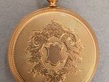 an image of a gold pocket watch sitting on a table