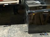 two black refrigerators sitting next to each other in a room