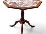 une table octogonale avec un plateau en marbre reposant sur un piètement en bois