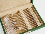 a lot of forks in a green box on the table